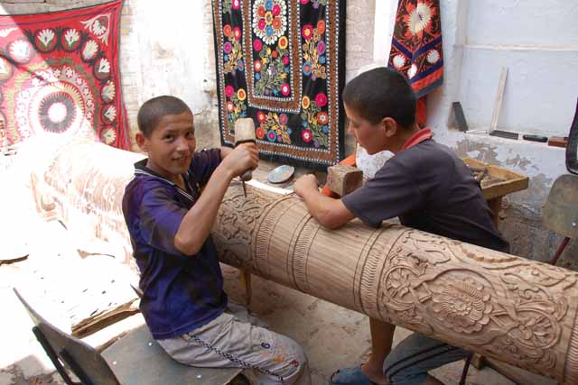 イチャンカラで柱を彫るヒワの少年（boys chiseling a column at Itchan Kala in Khiva）
