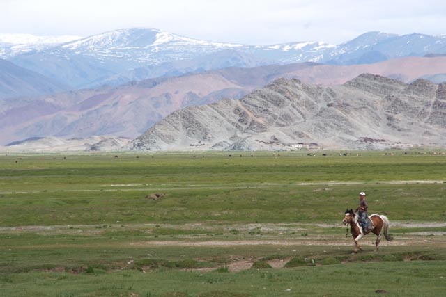 カザフ族集落で馬で駆ける少年