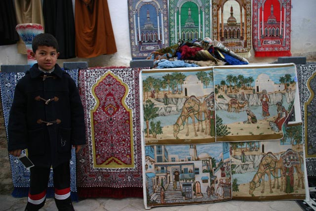 ケルアンのグランドモスクでカーペットを売る子（a boy selling carpets at the Great Mosque of Kairouan）