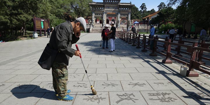 瀋陽（旧奉天）の清朝第二代皇帝ホンタイジ北陵（昭陵）公園で水筆で漢詩を認める男性